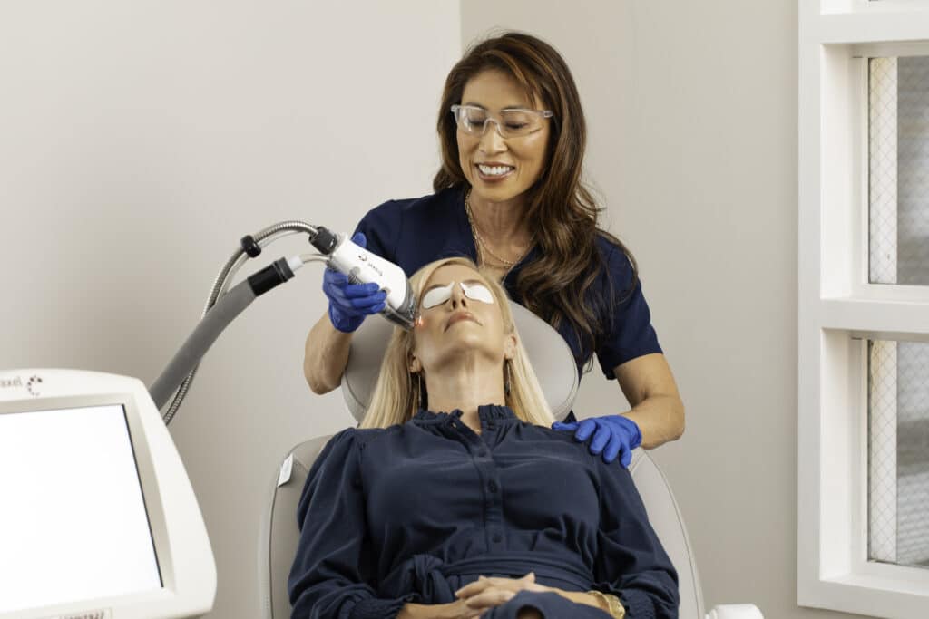 Provider performing a laser treatment on a patient